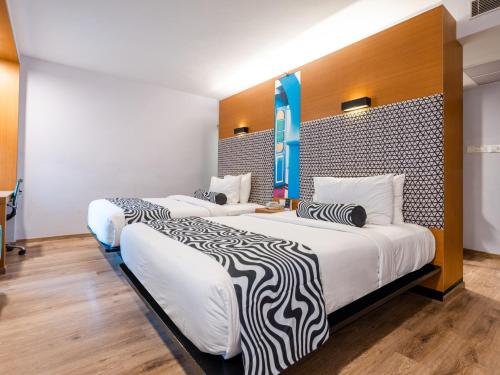 two beds in a hotel room with white walls at Sunday Hotel Chandigarh Zirakpur in Zirakpur