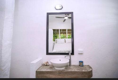 uma casa de banho com um lavatório branco e um espelho. em Banana Bay Beach Club em Eton