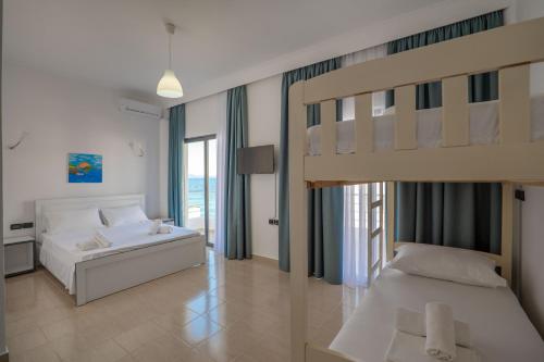a bedroom with two beds and a bunk bed at El Mare Hotel in Sarandë