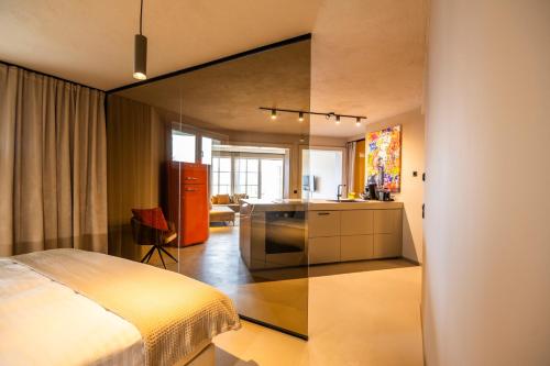 ein Schlafzimmer mit einem Bett und eine Küche mit einem Spiegel in der Unterkunft apart33 - Alpendorf in Salzburg in St. Johann im Pongau