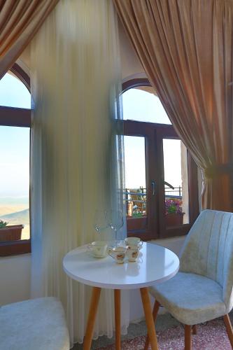 uma mesa branca, duas cadeiras e uma janela em Şems Inn em Mardin