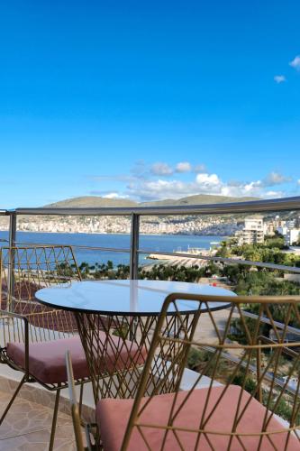 a table and chairs on a balcony with a view of the beach at El Mare Hotel in Sarandë