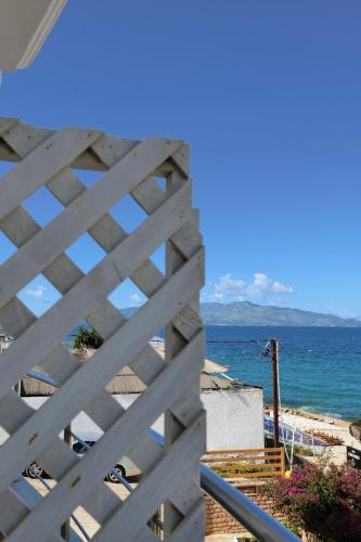 a view of the ocean through a wooden fence at El Mare Hotel in Sarandë