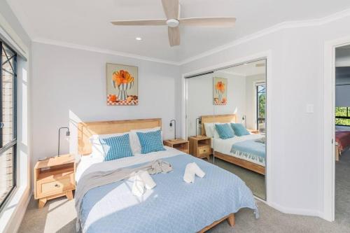 a bedroom with two beds and a ceiling fan at KozyGuru Gold Coast Broadbeach Holiday Home in Gold Coast