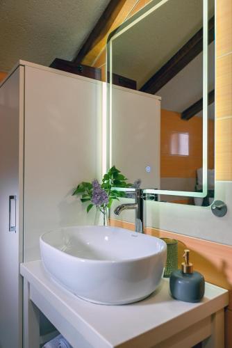 a white sink in a bathroom with a mirror at Villa Silentio Luxury with pool, jacuzzi & sauna in Podgora