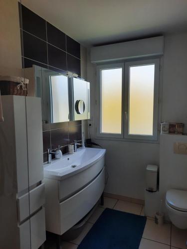 y baño con lavabo blanco y aseo. en Joli pavillon proximité ocean, en Saint-Nazaire