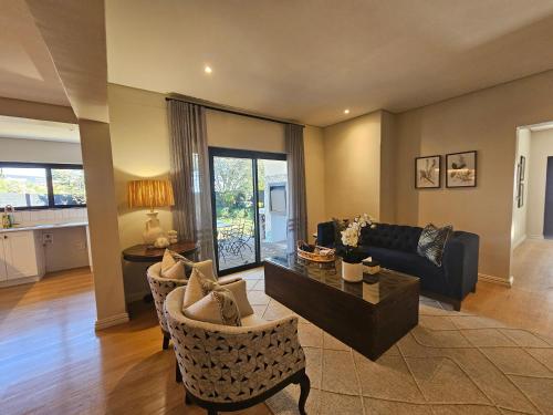 a living room with a couch and a table at Hilton Homestead by ANEW in Pietermaritzburg