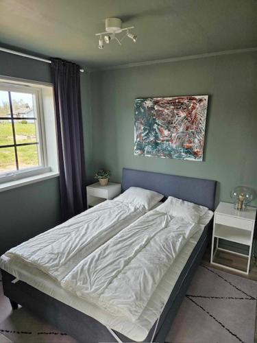 a bedroom with a bed and a painting on the wall at Ebbas stuga in Färjestaden