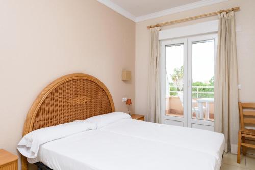 ein Schlafzimmer mit einem großen weißen Bett und einem Fenster in der Unterkunft Clavel by Oliva Nova in Oliva
