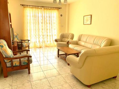 a living room with a couch and chairs and a table at Danaos complex in Paphos