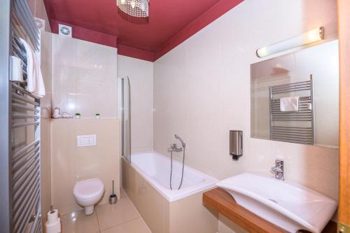 uma casa de banho com um lavatório, uma banheira e um WC. em Tatragolf Mountain Resort F208 em Veľká Lomnica