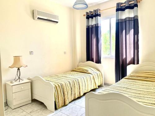 a bedroom with two beds and a window at Danaos complex in Paphos City