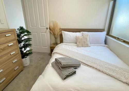 1 dormitorio con 1 cama grande y toallas. en 3-Bedroom Kinross Beachside Abode, en Kinross