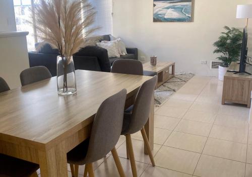 sala de estar con mesa de madera y sillas en 3-Bedroom Kinross Beachside Abode, en Kinross