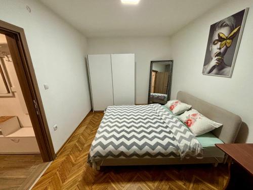 a small bedroom with a bed and a dresser at Apartment Milos in Belgrade