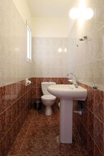 a bathroom with a white sink and a toilet at Danaos complex in Paphos