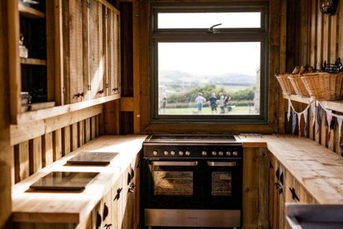 a kitchen with a stove and a window in it at 10 Roosters Ridge, Camp Tapnell in Yarmouth