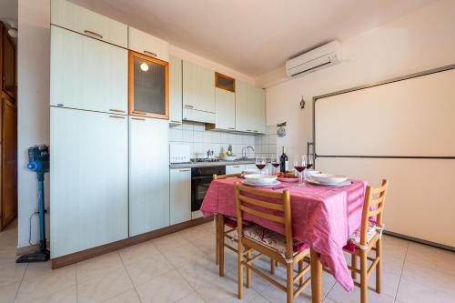 a kitchen with a table and chairs and a white refrigerator at AffittaSardegna-Casa Mirador in Agrustos