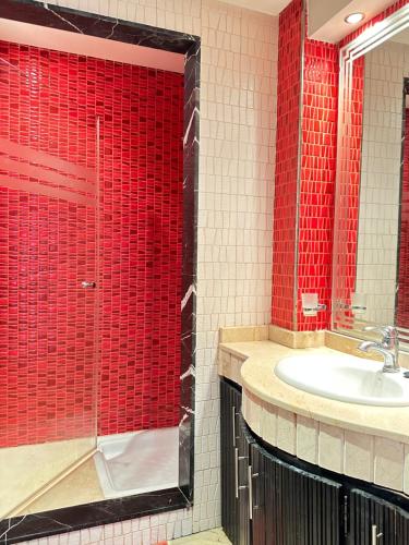 La salle de bains est pourvue d'un lavabo et de carreaux rouges. dans l'établissement Fabulous Apartment in Marina Agadir, à Agadir