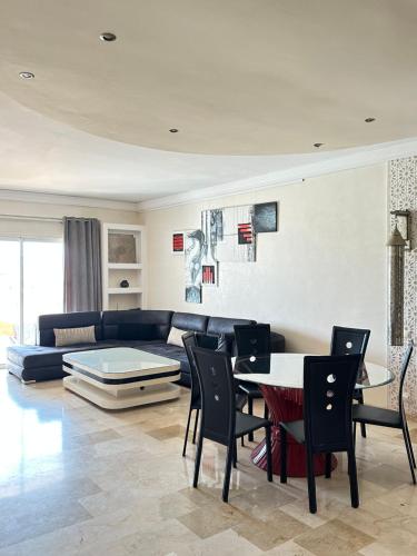 Fabulous Apartment in Marina Agadir في أغادير: غرفة معيشة مع أريكة وطاولة وكراسي