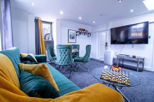 a living room with a blue couch and a table at Oxford Street - One Bed Lux in London