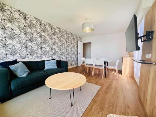 un salon avec un canapé vert et une table dans l'établissement Appartement Rénové de 48m² à Quiberon - Proche Plage, Parking Privé, Loggia Exposée Sud, 4 Pers. - FR-1-478-283, à Quiberon
