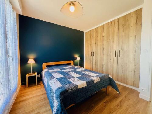 une chambre avec un lit et un mur bleu dans l'établissement Appartement Rénové de 48m² à Quiberon - Proche Plage, Parking Privé, Loggia Exposée Sud, 4 Pers. - FR-1-478-283, à Quiberon