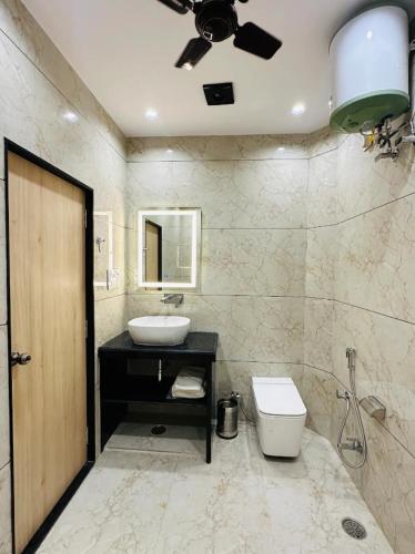 a bathroom with a sink and a toilet and a ceiling at M G Apartments in Jodhpur