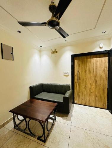 ein Wohnzimmer mit einem Sofa und einer Holztür in der Unterkunft M G Apartments in Jodhpur