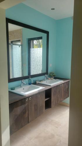 een badkamer met 2 wastafels en een grote spiegel bij La lavandière in Fox-Amphoux