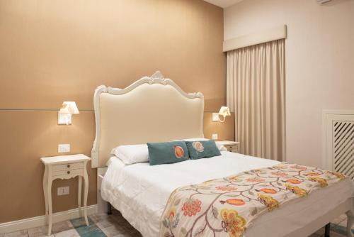 1 dormitorio con cama blanca y cabecero blanco en Certosa Suite en Nápoles
