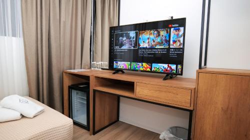 a television on a wooden stand in a room at 313 Villa City Center Hotel in Tirana