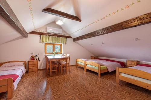 a attic bedroom with two beds and a desk at Fun and Games Homestead Lukec - Happy Rentals in Kostel