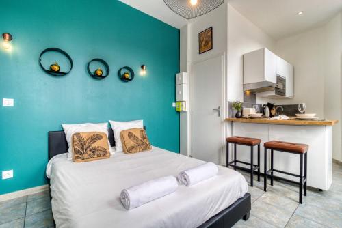 ein Schlafzimmer mit einem Bett und einer blauen Wand in der Unterkunft La Main d'Or - Confort - Calme - Centre in Abbeville