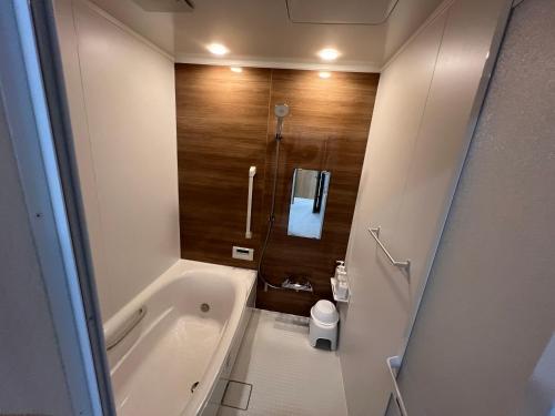 a bathroom with a bath tub and a toilet at Dia INN in Sumoto