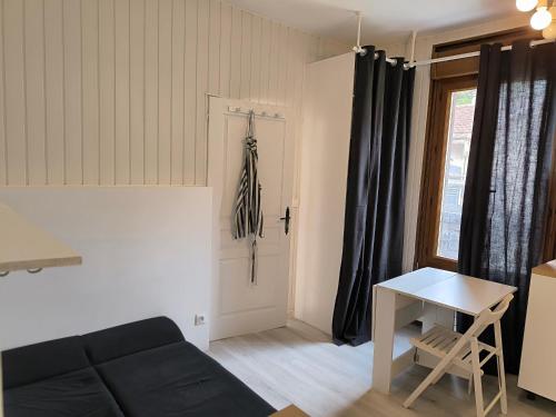 un salon avec un canapé noir et une table dans l'établissement Studio à 5 min du M7 Villejuif, à Villejuif