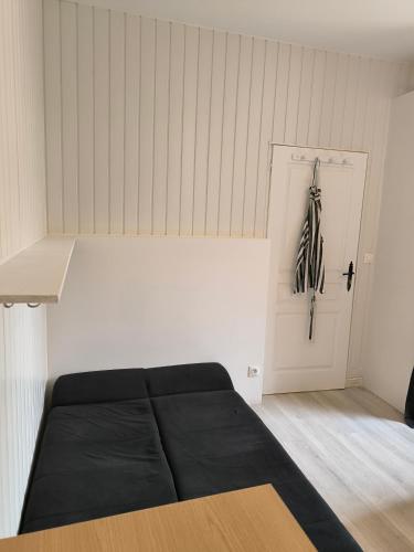 - une chambre avec un lit noir et une porte blanche dans l'établissement Studio à 5 min du M7 Villejuif, à Villejuif