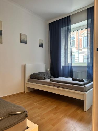 a bedroom with a bed and a window with blue curtains at Apartment mit Balkon im Stadtzentrum in Hannover