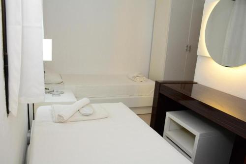 a white bathroom with two beds and a mirror at Bodrum Park Hotel in G&uuml;mbet