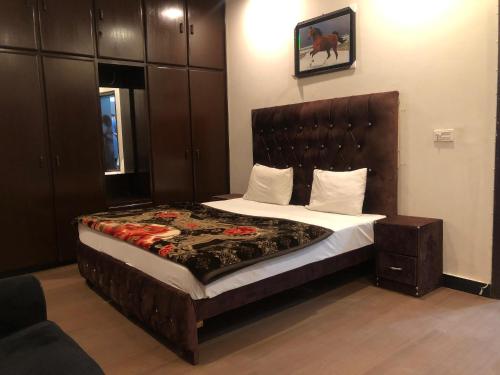 Defence-Mark-Hotel في لاهور: غرفة نوم بسرير كبير في غرفة