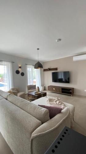a living room with a couch and a flat screen tv at Villa Milandro - Luxus & Ruheoase in Lašći