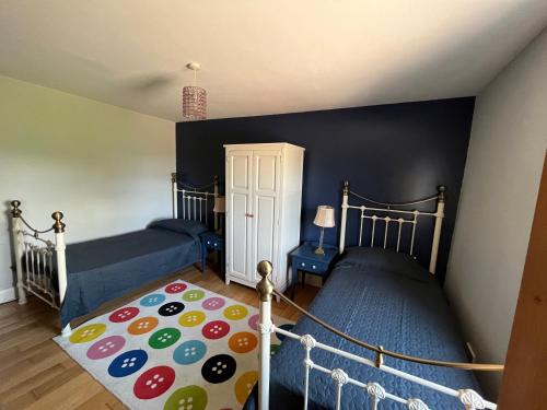 a bedroom with two beds and a rug at Seaview House Reenard South in Cahersiveen