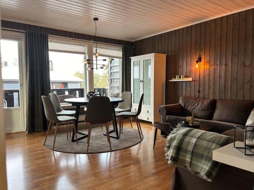 a living room with a table and chairs and a couch at Leilighet Ski in/out, golf in Vradal