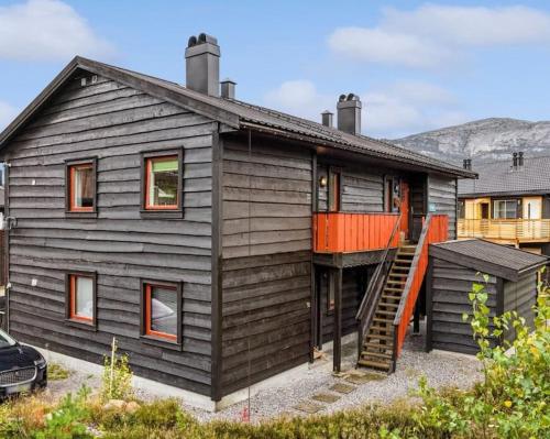 a house with an orange deck on the side of it at Leilighet Ski in/out, golf in Vradal