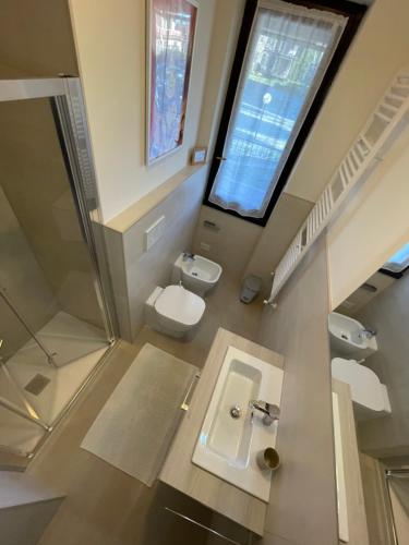 a bathroom with a sink and a toilet and a window at La Casa di Simo Appartamento con terrazzo in Salice Terme