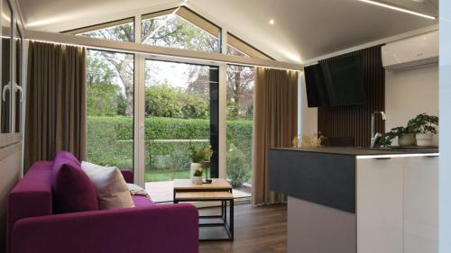 索勒恩的住宿－LandZeit - get your tiny moments，一间带紫色沙发的客厅和一间厨房
