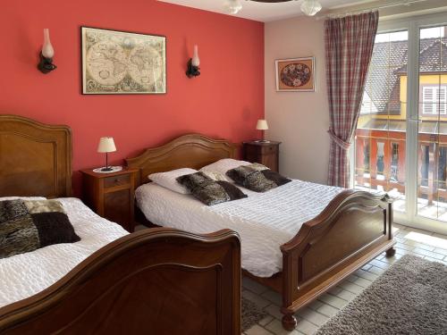 Duas camas num quarto com paredes vermelhas em Gite Haydi em Itterswiller
