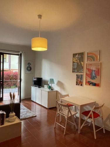 a living room with a table and chairs and a kitchen at La Casa di Simo Appartamento con terrazzo in Salice Terme