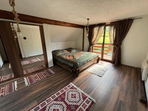 a bedroom with a bed and a mirror and rug at Villa Mona Zeleni Vir in Olovo