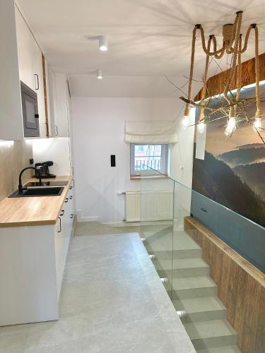 a kitchen with a glass staircase in a room at Pod Horodkiem in Cisna